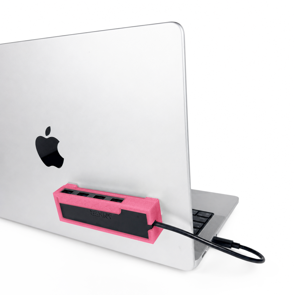 Light pink HubMount holding an Anker USB hub, securely attached to an open MacBook lid at a 45-degree angle.