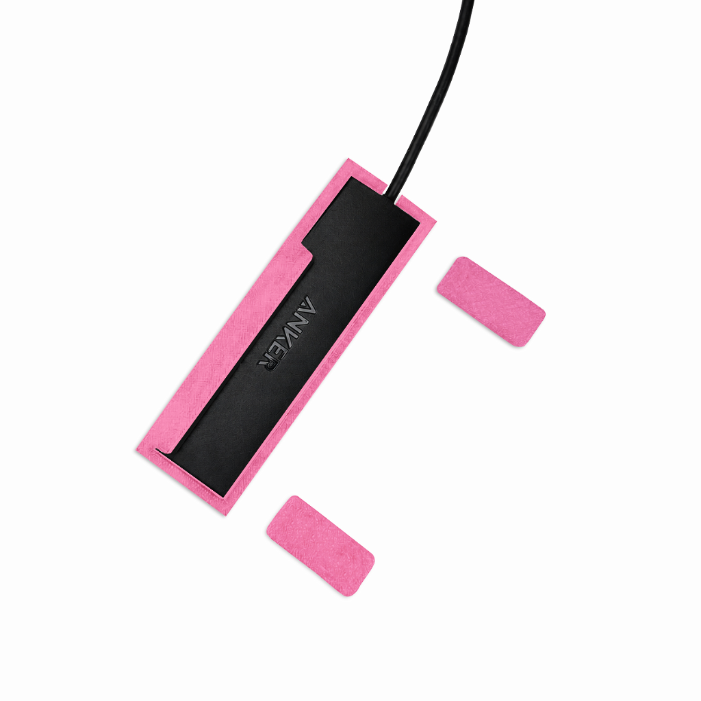 Top view of light pink HubMount magnetic case holding an Anker USB hub, with adhesive magnetic feet positioned beside it.