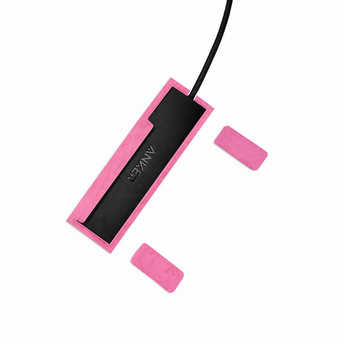 Top view of light pink HubMount magnetic case holding an Anker USB hub, with adhesive magnetic feet positioned beside it.