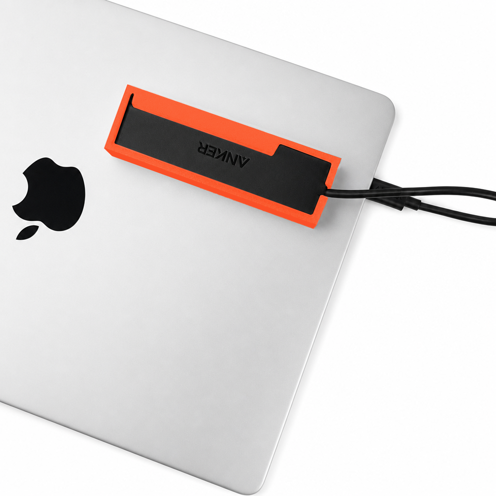 Top view of an orange-red HubMount mounted on a closed MacBook lid.