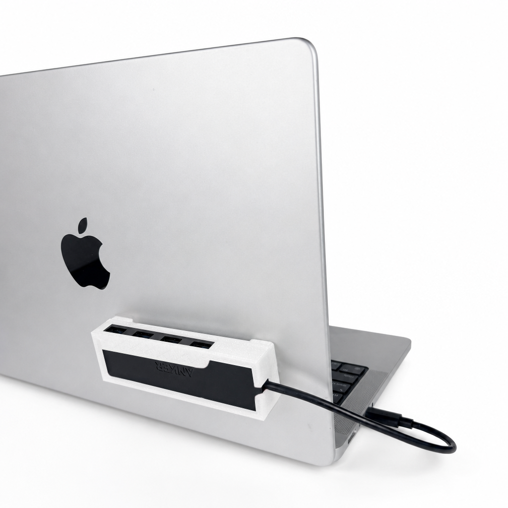 White HubMount holding an Anker USB hub, securely attached to an open MacBook lid at a 45-degree angle.
